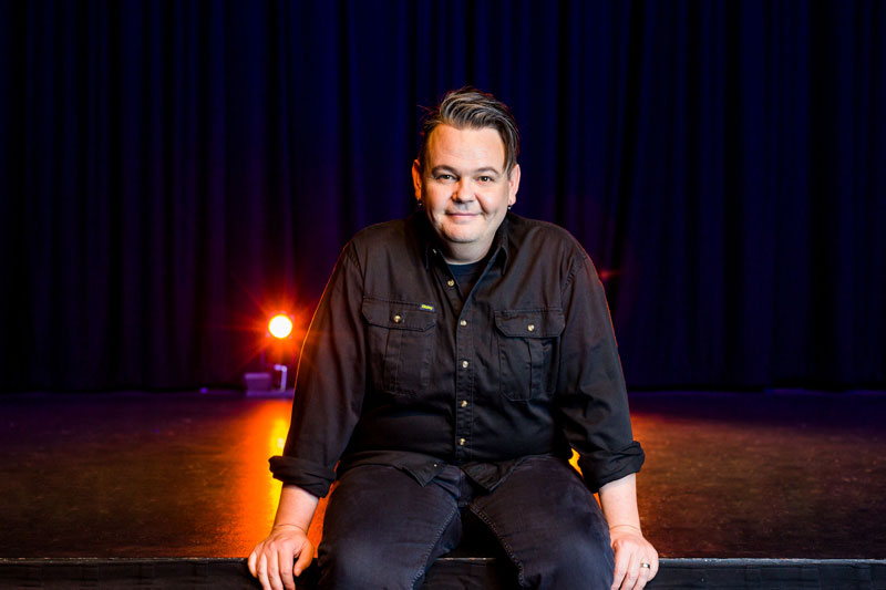 Sam Hemphill sitting on a stage